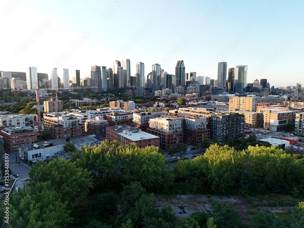 Fototapeta premium Aerial view of modern waterfront district with high-rise buildings and riverside paths, Montreal twilight skyline. g.