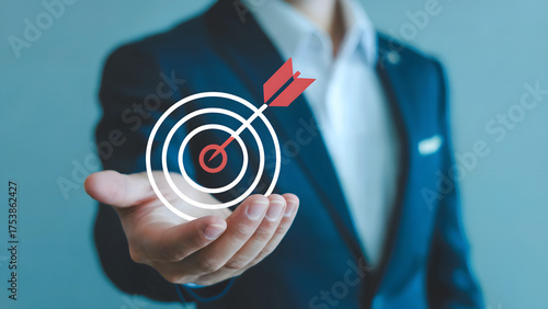 Businessman holding target with arrow in hand representing achievement and goal orientation concept