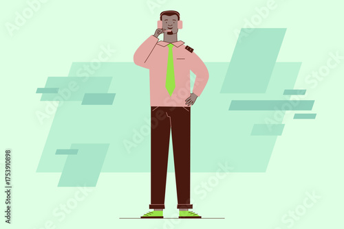 Man wearing headset standing confidently while talking on phone. Man dressed in pink shirt, green tie, and brown pants, set against green background