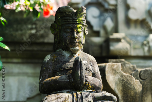 Ancient Balinese Stone Statues Covered in Moss in a Tropical Temple Garden