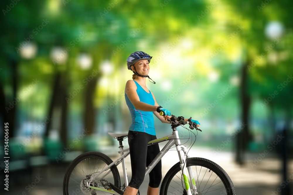 Naklejka premium Young happy cyclist riding bicycle on road.