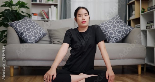 Handheld shot, Happy young woman practicing yoga with relaxation in living room at home. Leisure activity. Health care.