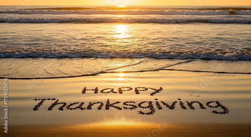 Fototapeta Naklejka Na Ścianę i Meble -  Happy thanksgiving message written in sand on a beach at sunset