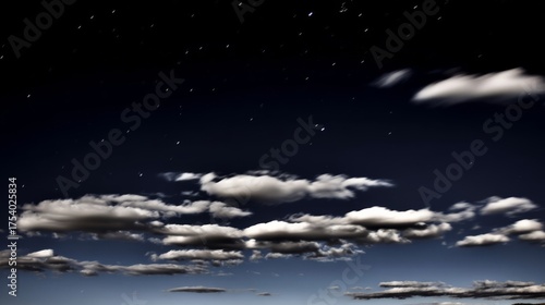 Clear night sky with white clouds and stars, featuring a motion blurry cloud against dark blue space,