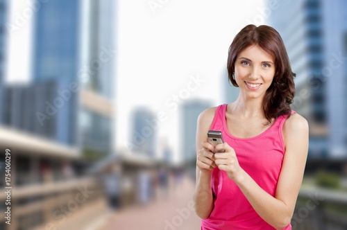 Free Download Happy woman using smartphone walking in city - GFXLoad