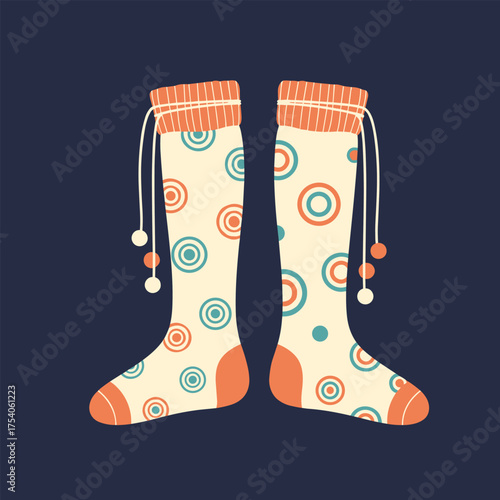 A pair of knee high socks with a playful circle pattern and pom poms.