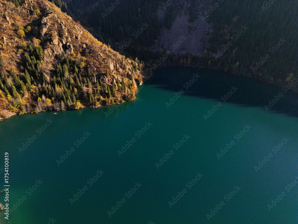 Obraz premium Lake Issyk in the rays of the setting sun. National Nature Park. Mountainous area with different vegetation.