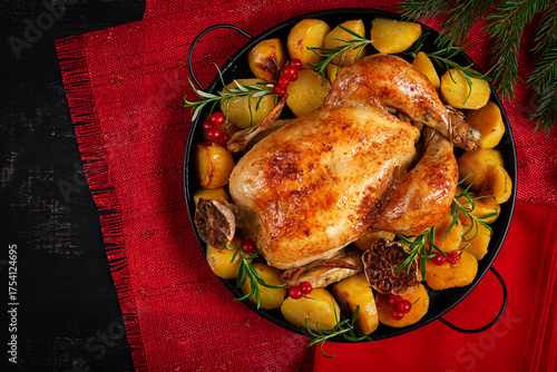 Roasted chicken with potatoes and Christmas decoration. Baked chicken or turkey. Table setting. Top view, flat lay