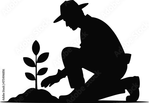 Gardener silhouette kneeling to plant a small seedling in the soil