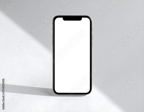 A black smartphone stands upright with a blank white screen against a white background with a diagonal shadow.