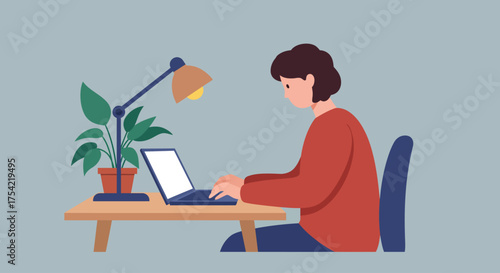 A person sits at a desk, illuminated by a desk lamp, diligently working on a laptop computer with a potted plant nearby.