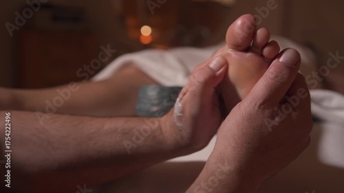 Wallpaper Mural Close-up view of professional therapist massaging toes and foot with cream in warm spa light, showing wellness, reflexology, and relaxation therapy for stress relief and body care. Torontodigital.ca