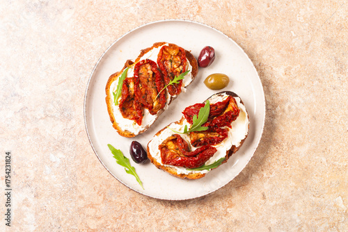 Toast with cream cheese and dried tomatoes. Open sandwich with arugula, bread, tomatoes, olives and oil. 