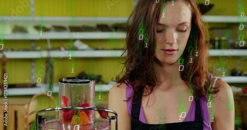 Juice attendant in purple top and apron blending fruit in juicer behind counter, green code overlay