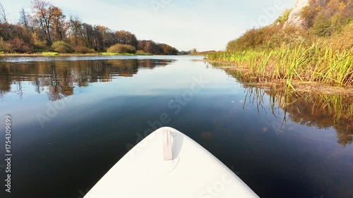 Enjoy a serene paddleboarding adventure on clear waters, surrounded by vibrant autumn foliagea perfect escape into natures beauty and tranquility, inviting you to relax and unwind