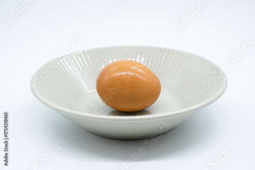 Boiled eggs in a circular bowl on a white background