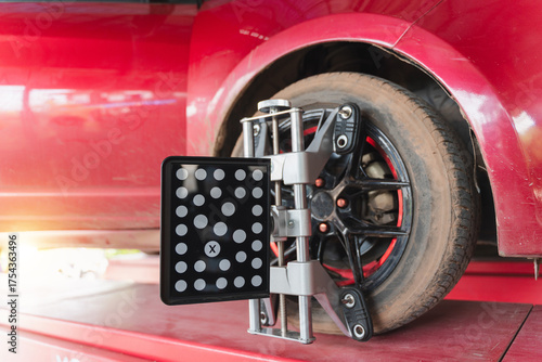 Fotografie Vehicle wheel alignment process with high-tech equipment capturing precise measu