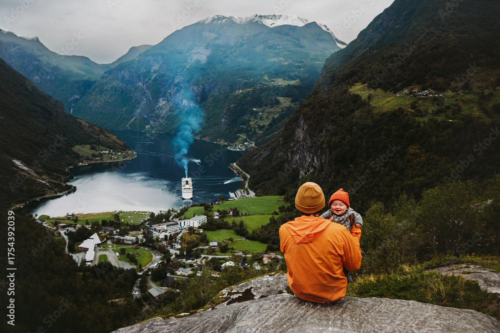 Fototapeta premium Family father with funny baby traveling in Norway vacations outdoor parent and infant child sightseeing Geiranger fjord view landmark summer holidays tour