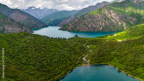 Aerial view of Sary-Chelek Lake in Kyrgyzstan. Deep blue alpine water surrounded by forested mountains and golden valleys within a pristine biosphere reserve