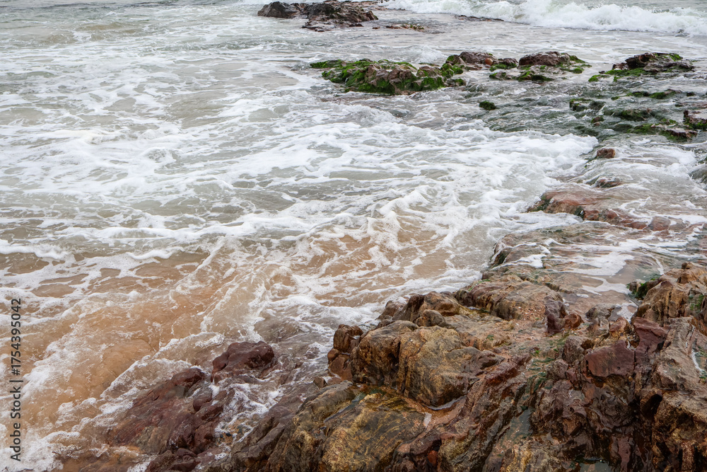 Fototapeta premium Old rocks on the seaside. Beautiful background of beach water flowing on the rocks.
