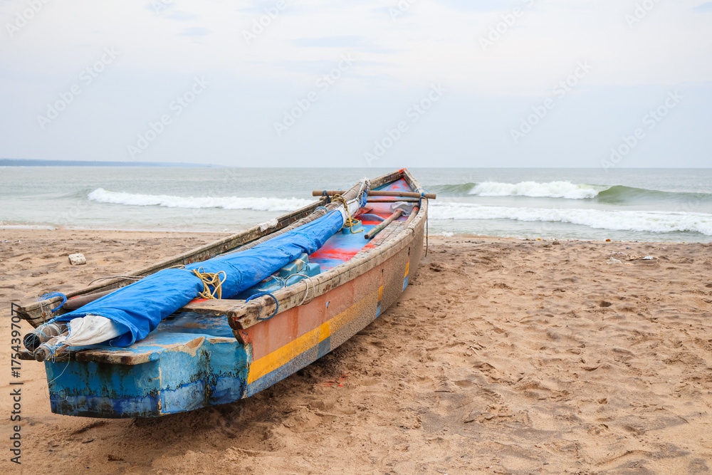 Obraz premium Motor boat moored at the sea shore. Traditional fishing boats and the beach landscape.
