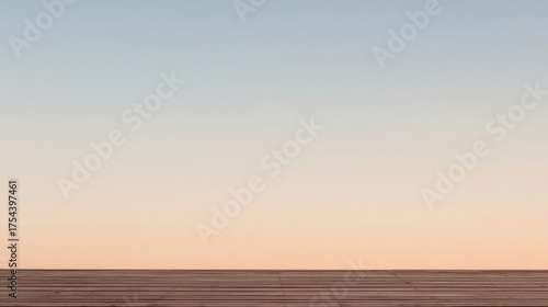 A serene horizon with a vast pale blue sky transitioning evenly to soft orange hues at sunset,
