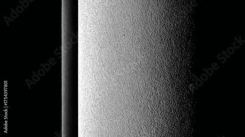 A textured surface with a gradient from light to dark, emphasizing contrast and detail,