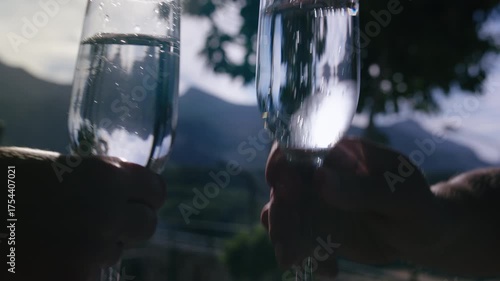 Couple Celebrating with Sparkling Champagne Glasses Against Beautiful Mountain Background