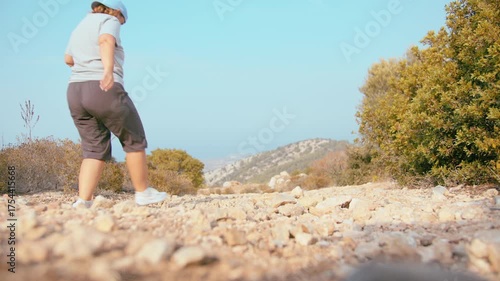 Female Traveler Walking Across Stony Mountain Path Surrounded by Scenic Natural Panorama