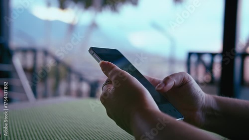 Female Hands Holding Smartphone on Balcony with Mountain View While Browsing News Feed