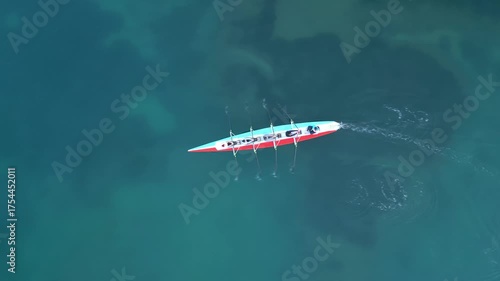 Sport Canoe with a team of four people rowing on tranquil water, Aerial view. High quality 4k footage
