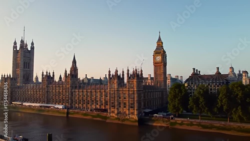 Houses of Parliament and Big Ben seen across river during sunset with golden hour lighting