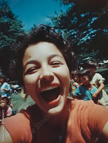 A person expresses pure joy and laughter while surrounded by happy children in a bright sunny outdoor park setting