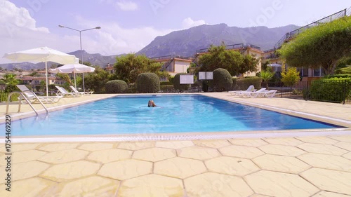 Female Tourist Relaxing and Swimming in Clear Pool Water at Sunny Villa