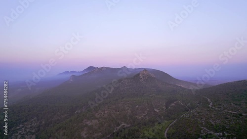 Sunset Over Mountain Range Captured by Drone with Curvy Serpentine Road Below