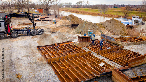Aerial view on excavator and tow truck as they move part of vessel