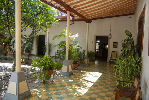 Colonial courtyard with plants and tiled floor, traditional architecture and natural light inside a historic Latin American house