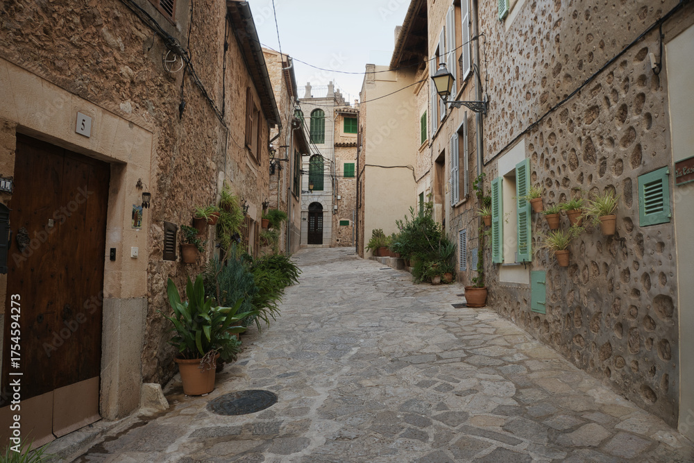 Fototapeta premium A narrow street with a stone wall in valldemossa majorca