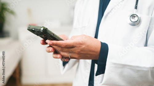 Fotografia Doctor Using Smartphone In Clinic With Stethoscope Draped Over White Coat For Me