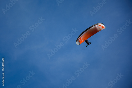 Powered paraglider. Paramotor. Microlight. ULM ultralight motorized up in the bright blue sky.