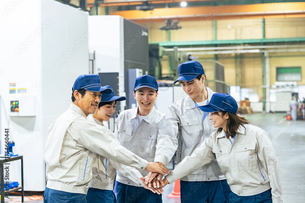 Fototapeta premium 工場の中で円陣を組む作業員グループ