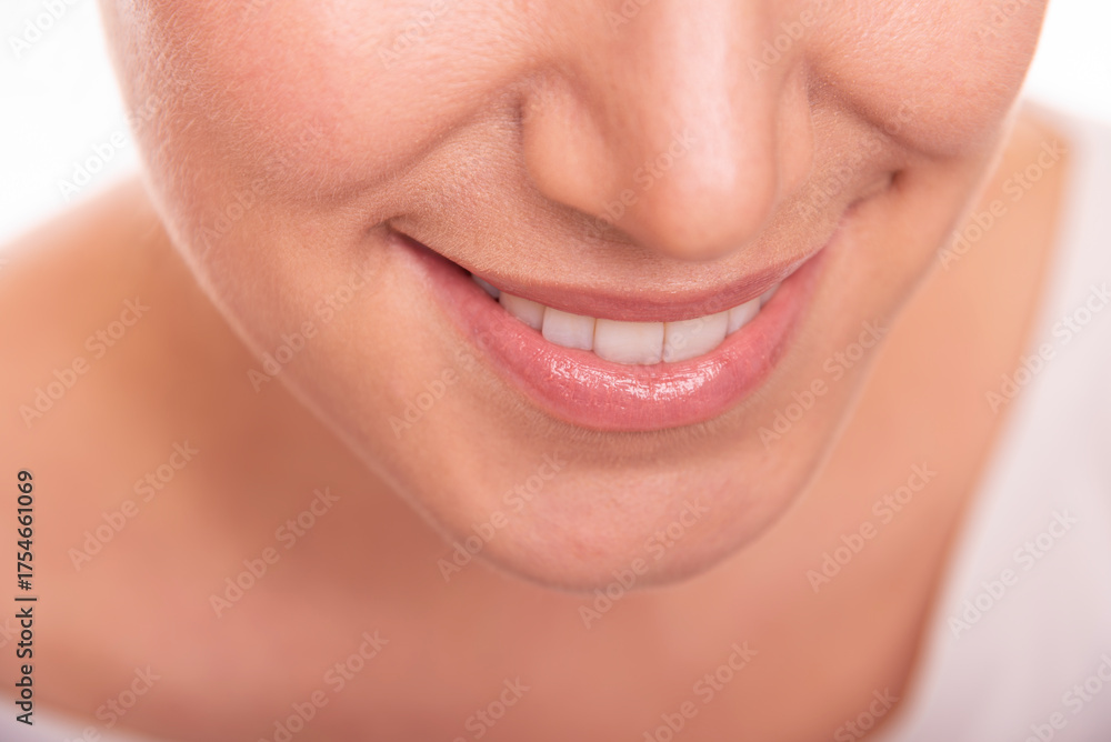 Obraz premium Close-up image of a smiling woman showing her white teeth and natural lips, representing happiness, confidence, and dental health.