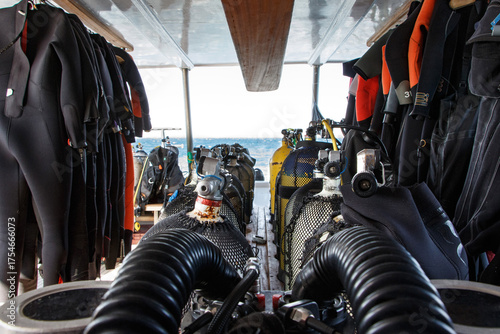 Scuba diving equipment arranged neatly on a boat, showcasing wetsuits and tanks, with ocean view in the background, emphasizing adventure and exploration in underwater activities. Red sea, Egypt