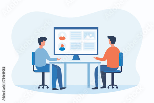 Two people sitting at a desk looking at a computer screen displaying profiles and images in a modern office setting