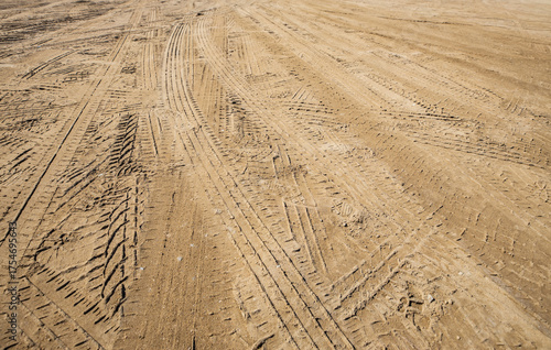 Vast expanse of textured earth displays intricate tire tracks creating a compelling visual of industry and raw natural power