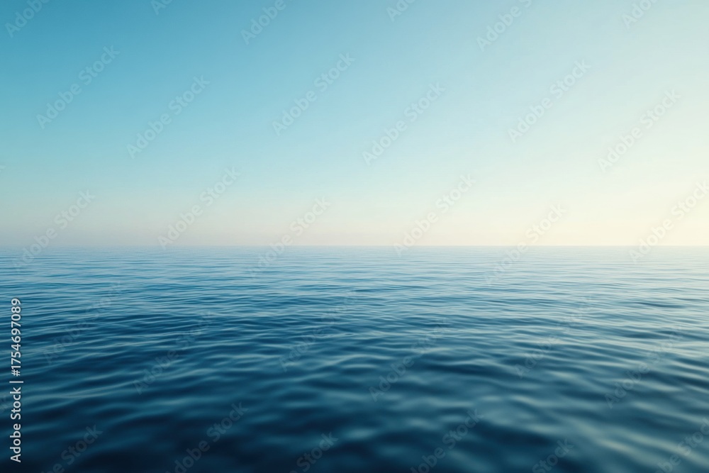 Obraz premium Infinite Horizon: A serene and expansive vista of a calm ocean merges seamlessly with a tranquil sky. The water's surface gently ripples under a gradient of light.