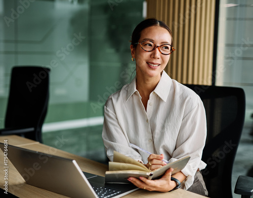 Portrait of a young businesswoman  or a young entrepreneur or a student young woman working on tablet or laptop  computer working in office