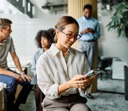 Portrait of a group of young business people having a meeting in the office. Teamwork and success concept, portrait of a smart young businesswoman using a smartphone phone and texting