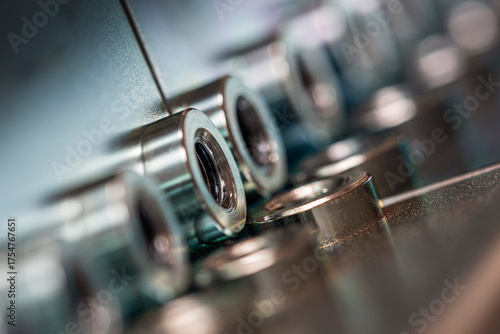 Steel plate and threaded holes, raw metal texture and light, in close-up