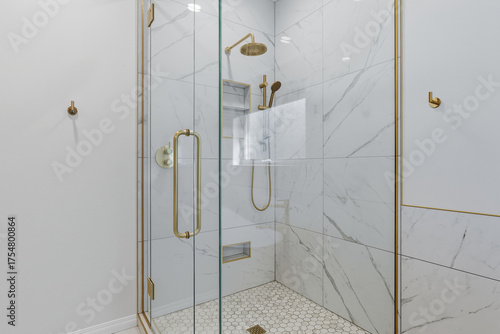 Fotografie Bathroom with a gold shower head and a glass door